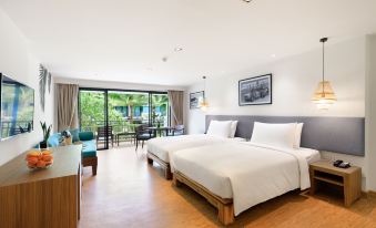 a modern hotel room with two beds , a balcony , and a dining area , all decorated in white and gray colors at Outrigger Khao Lak Beach Resort