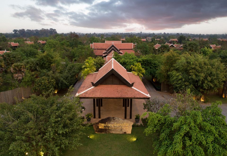aerial view of a house surrounded by trees , with a lawn in front of it at Mane Hariharalaya