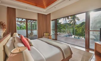 a large bed with a white and red striped blanket is in a room with a sliding glass door that leads to an outdoor pool at The Farm at San Benito