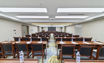 a large conference room with rows of chairs and tables , water bottles on each table at Tibet Hotel