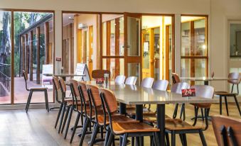 a large dining room with a long table surrounded by wooden chairs , and a window providing natural light at Wilpena Pound Resort