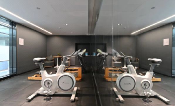 The room features multiple exercise machines and other equipment, including an indoor gym at Atour X Hotel Beijing Sanlitun Taikoo Li