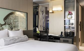 A bedroom with a large bed and desk in the middle, alongside an open space at Hyatt Centric Victoria Harbour Hong Kong