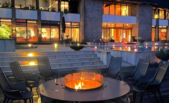 a fire pit is set up in a courtyard with chairs and tables surrounding it at Sankara Hotel & Spa Yakushima