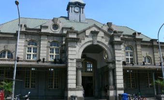 a large building with a clock tower , surrounded by a parking lot filled with cars at 101 Hotel