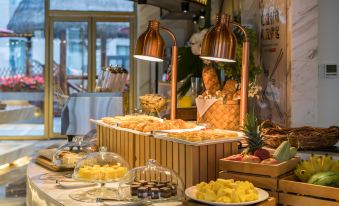 A buffet table in the main dining room of the hotel is set with a variety of food and drinks at VOYAGE INTERNATIONAL HOTEL