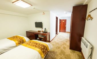 The middle room features a large bed and desk, with two doorways that lead to another bedroom at Guangmingding Hotel