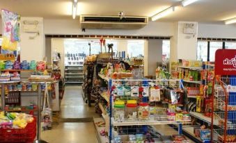 a convenience store with aisles filled with various products , including drinks , snacks , and food items at Kim Hotel at Bangplong