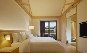 The bedroom features large windows and a balcony that overlooks the rest area, with an unmade bed at The Westin Yilan Resort