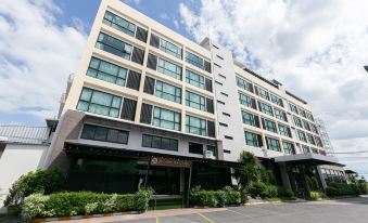 "a modern , multi - story building with glass windows and a sign reading "" bangkok hotel "" in front" at Grand Ratchapruek Hotel