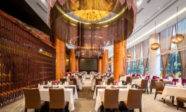 In the dining room, there are tables and chairs, and an elegant chandelier hangs from the ceiling at Jianguo Hotel, Guangzhou