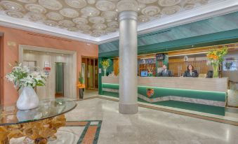 a hotel lobby with a reception desk , a marble floor , and several people standing and sitting around it at Grand Hotel Adriatico