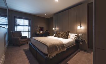a luxurious bedroom with a large bed , brown leather headboard , and two nightstands on either side of the bed at Dakota Edinburgh