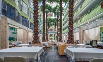 The restaurant offers indoor dining with tables and chairs that overlook the pool area at Shanshui Trends Hotel (Shenzhen Huaqiangbei)