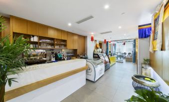 a restaurant with a long dining table and chairs , as well as a kitchen area at Tibet Hotel