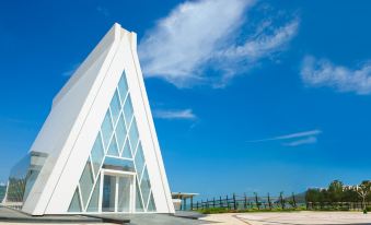 There is a large building with the sky in front and another building on top that has a unique shape at Auberge Discovery Bay Hong Kong