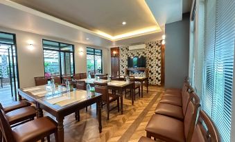 a large , well - lit dining room with multiple tables and chairs arranged for a group of people at The Mangrove Hotel