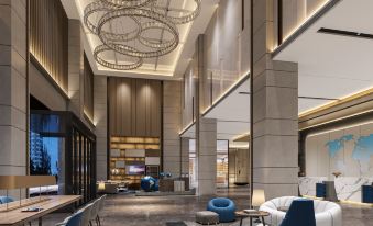 The hotel lobby features a spacious area with a large table and chairs, as well as other amenities at Kyriad Marvelous Hotel (Xinyu Jiuding Kongmujiang Store)