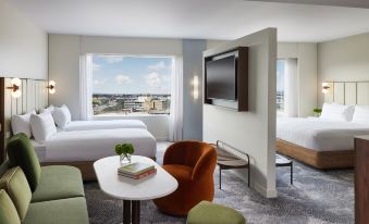 a modern hotel room with a large window , two beds , and a tv , along with a table and chairs at PARKROYAL Melbourne Airport