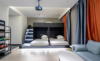 a modern bedroom with bunk beds and a black accent wall in the adjacent small living area at Yueta X E-sports Hotel (Jiangnanxi Subway Station)