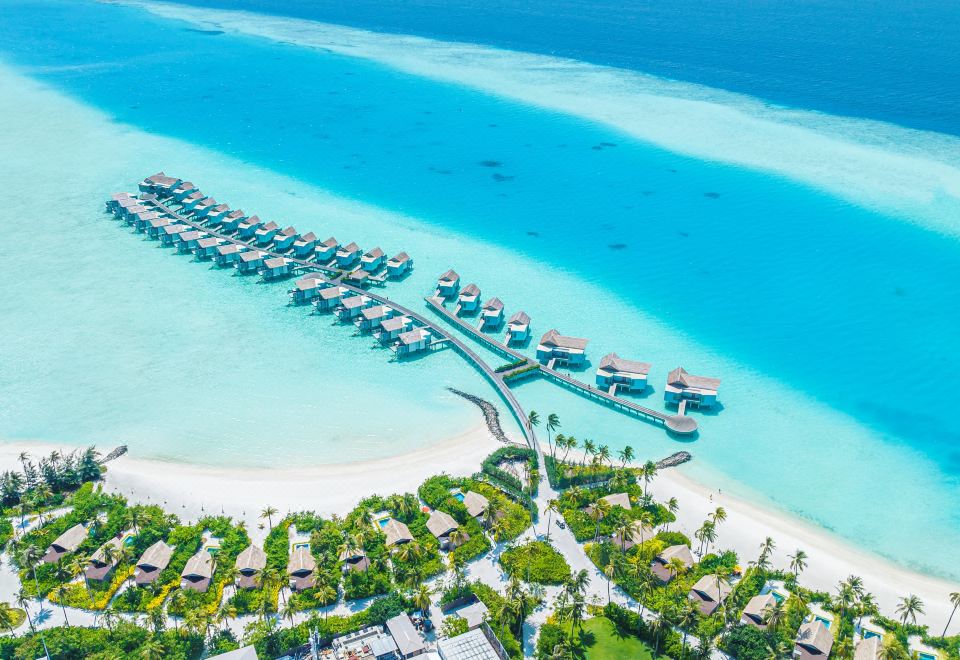a resort situated on a tropical island , with clear blue water and lush green vegetation at Hard Rock Hotel Maldives