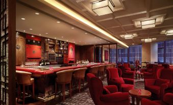 A room is furnished with red chairs and tables, complemented by an area rug in the center at Hyatt Regency Hong Kong, Tsim Sha Tsui