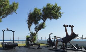 a man is working out in a backyard gym , lifting weights and posing for a picture at Civitel Creta Beach