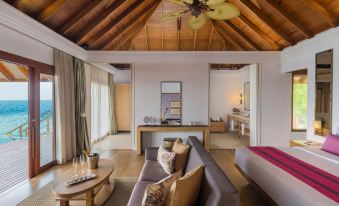a spacious living room with a couch , chairs , and a dining table in the background at Dusit Thani Maldives - 50% discount on Transfers for stay until 20 Dec 2025