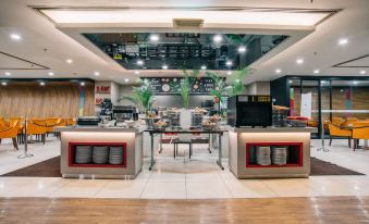 a modern restaurant with a bar area and a dining table , where people are seated and enjoying their meals at Oakwood Hotel and Residence Kuala Lumpur