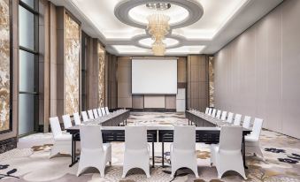 a conference room with a long table , chairs , and a large screen , all set up for a meeting at Sheraton Can Tho