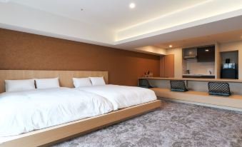 A bedroom with two beds and a kitchen attached to it, located next to another room at Stayat Osaka Shinsaibashi East