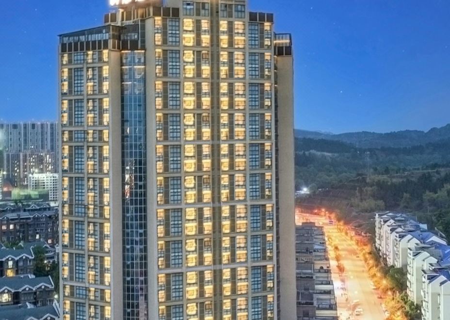 "a tall building with a sign that reads "" starlight hotel "" is illuminated against the night sky" at Como Hotel