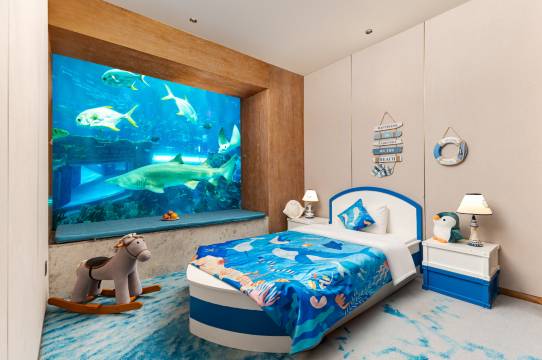Children’s ocean-themed suite at Dali Ocean Hotel with a shark aquarium window