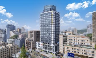 The aerial view shows a large building with apartments and other buildings in the background at Jinfan Wanyuan Hotel