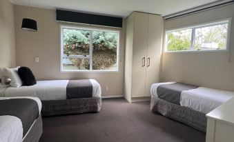 a room with two beds , one on the left and one on the right side of the room at Asure Green Gables Motel