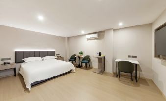 a modern bedroom with a large bed , white bedding , and a desk area near the bed at Diamond Hotel (Liancheng Guanzhishan Airport)
