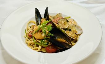 A plate of pasta and meat is accompanied by another dish at Ibis Hong Kong North Point