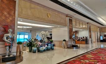 The hotel lobby features a large table with flowers on each side in the front at Golden Crown China Hotel