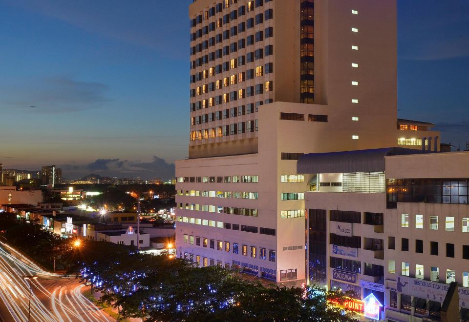 "a tall building with a blue sign that reads "" parkview "" is lit up at night" at Pearl View Hotel Prai, Penang