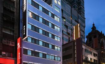 a city street at night , with a tall building on the left side of the scene at Le Room Hotel Taoyuan