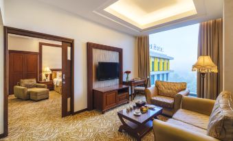 a modern living room with a large flat - screen tv , comfortable furniture , and a view of the city at Grand Artos Hotel & Convention