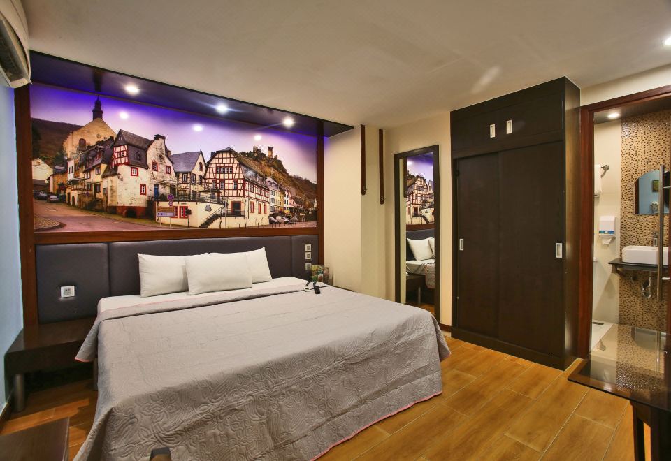 a large bed with a white comforter and pillows is in a room with wooden floors at Eurotel Angeles