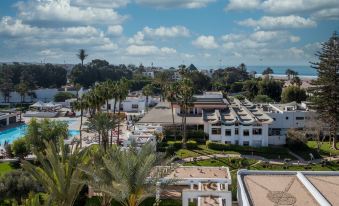 a view of a city with palm trees , buildings , and a pool from an aerial perspective at Allegro Agadir