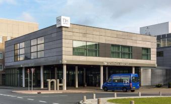 a building with a large glass window and the number 7 1 4 is shown in the image at NH Amsterdam Schiphol Airport