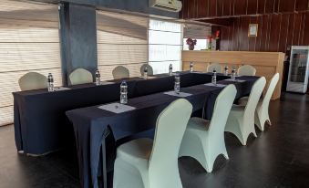 a conference room with several chairs arranged in a semicircle around a table , and a television mounted on the wall at Louis Kienne Hotel Simpang Lima