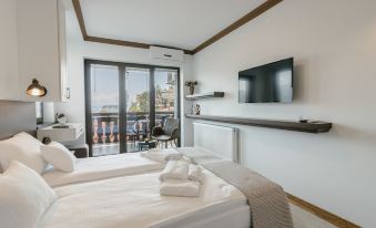 a modern hotel room with a large window offering views of the city , a bed with folded towels , and a flat - screen tv on the at Villa Varosh