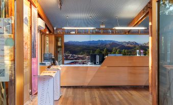 a wooden reception desk with a large window overlooking a scenic mountain view in the background at Wilpena Pound Resort