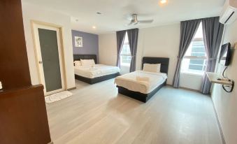 a spacious bedroom with two beds , one on each side of the room , and hardwood floors at Havona Hotel - Kulai