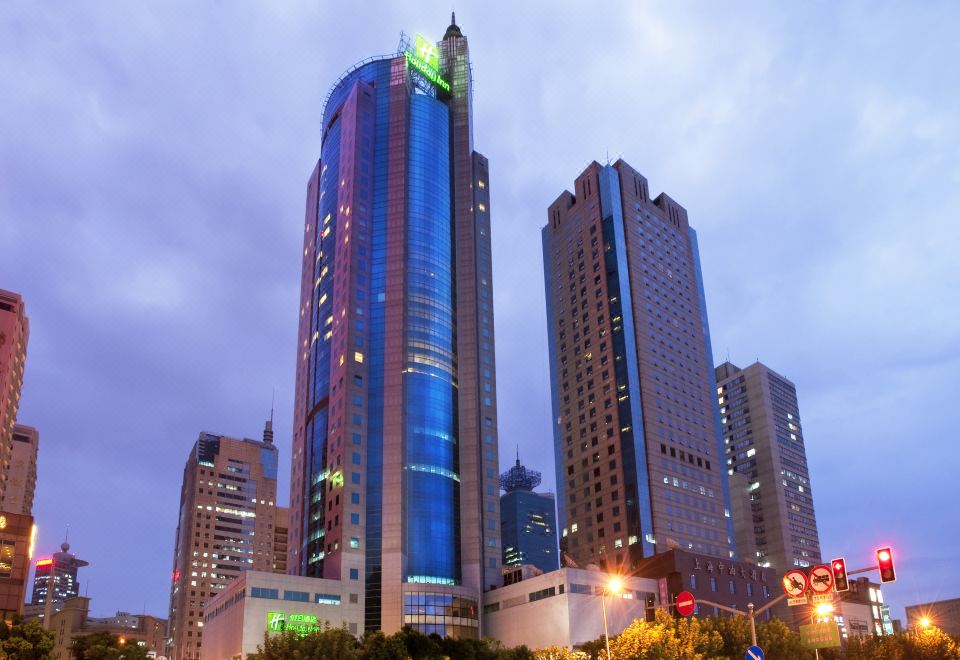 A city with tall buildings and large windows creates a captivating view during dusk or nighttime at Holiday Inn Shanghai Pudong