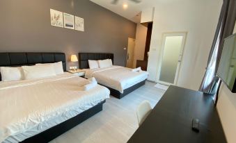 a hotel room with two beds , a desk , and a ceiling fan , along with a door leading to another room at Havona Hotel - Kulai